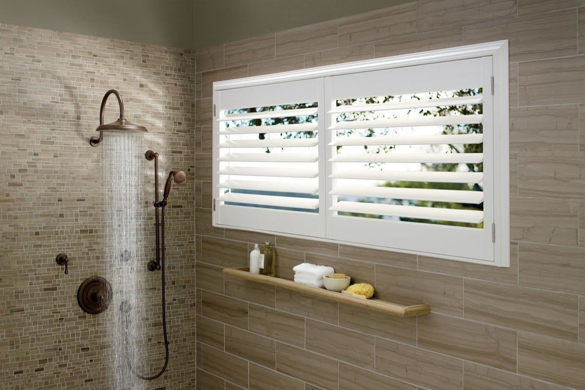 Hunter Douglas Palm Beach™ Polysatin™ Vinyl Shutters® in a bathroom filling up with steam