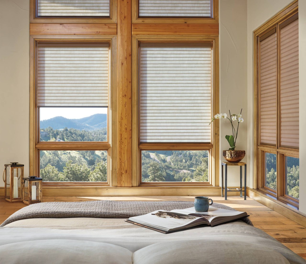 Picturesque rustic bedroom featuring several windows covered by Hunter Douglas Sonnette® Roller Shades near Campbell, CA
