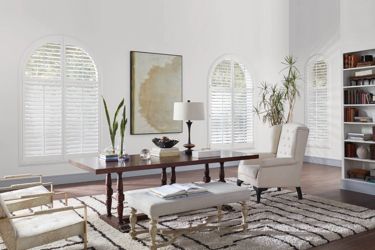 White Hunter Douglas NewStyle® Composite Shutters on three arched windows in a home office at Blinds 'N' Shades Express near Campbell, CA